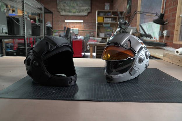 3D printed carbon fiber prop helmet next to painted finished product