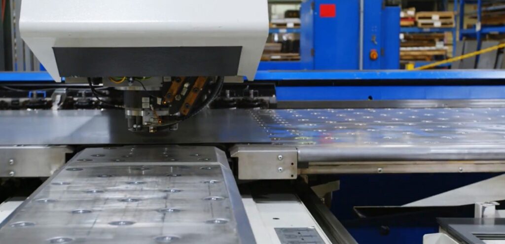 A CNC machine operating on a large metal sheet in a high-tech manufacturing facility, showcasing precise toolpath execution.