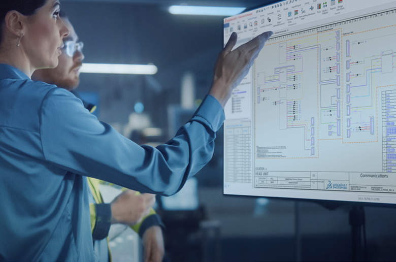 A woman in a blue shirt points at a large screen displaying a detailed electrical schematic.